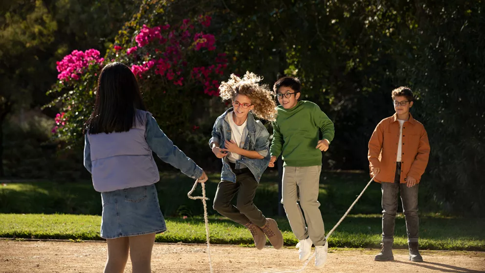Four children playing outside while wearing glasses